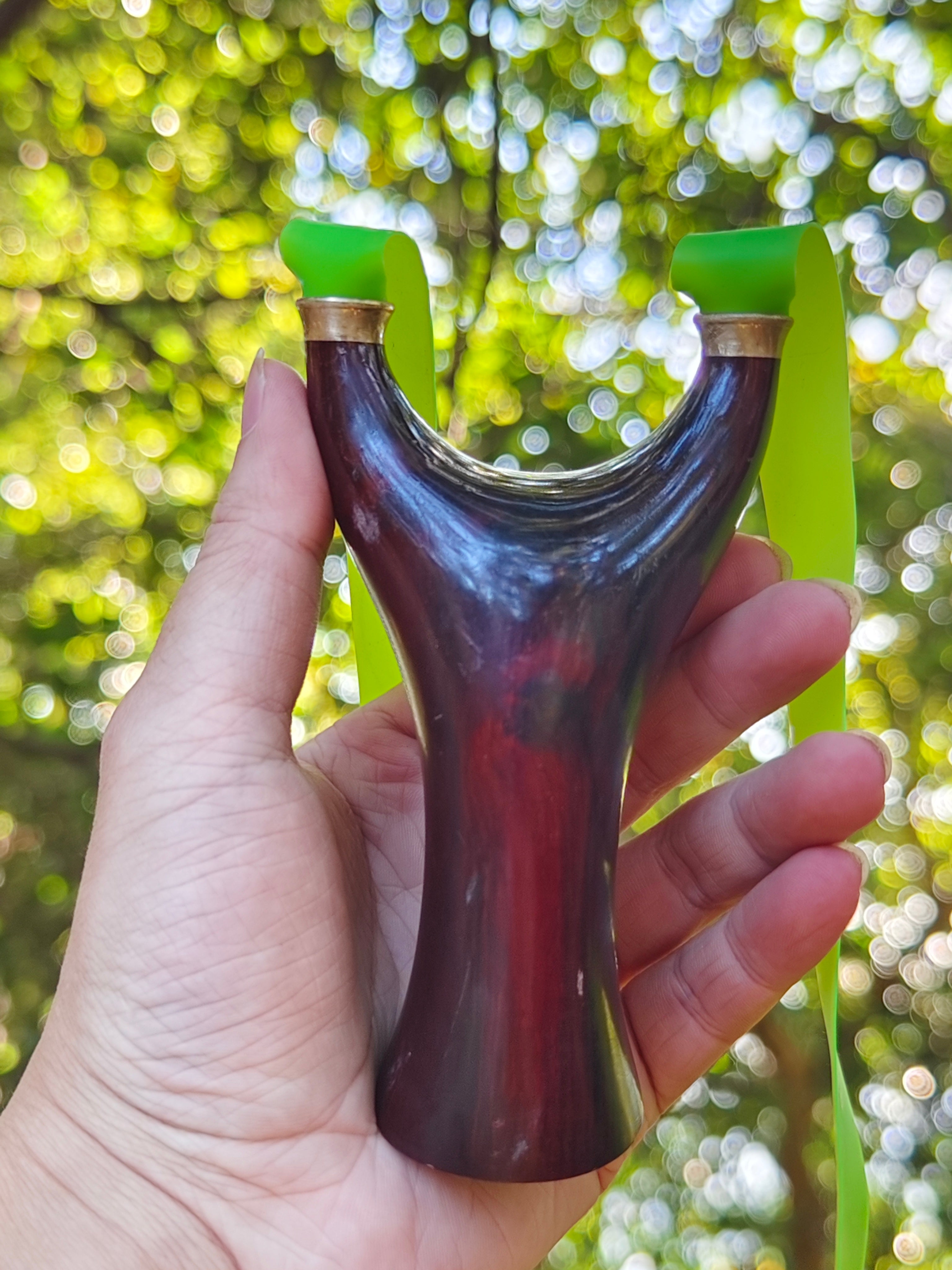 Natural rosewood slingshot featuring hand-polished craftsmanship and ergonomic grip for precision.