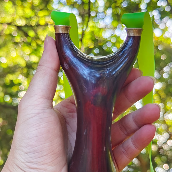 Natural rosewood slingshot featuring hand-polished craftsmanship and ergonomic grip for precision.