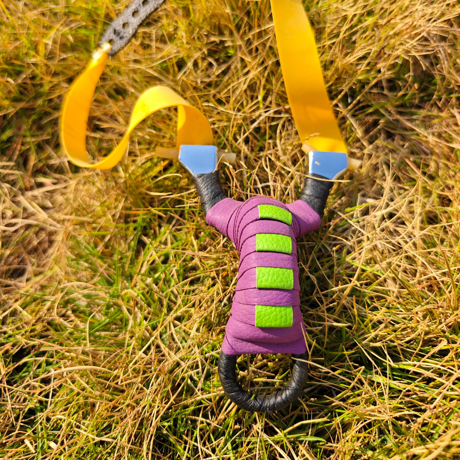 Pocket Snipe precision-engineered stainless steel slingshot with stylish purple and black design.